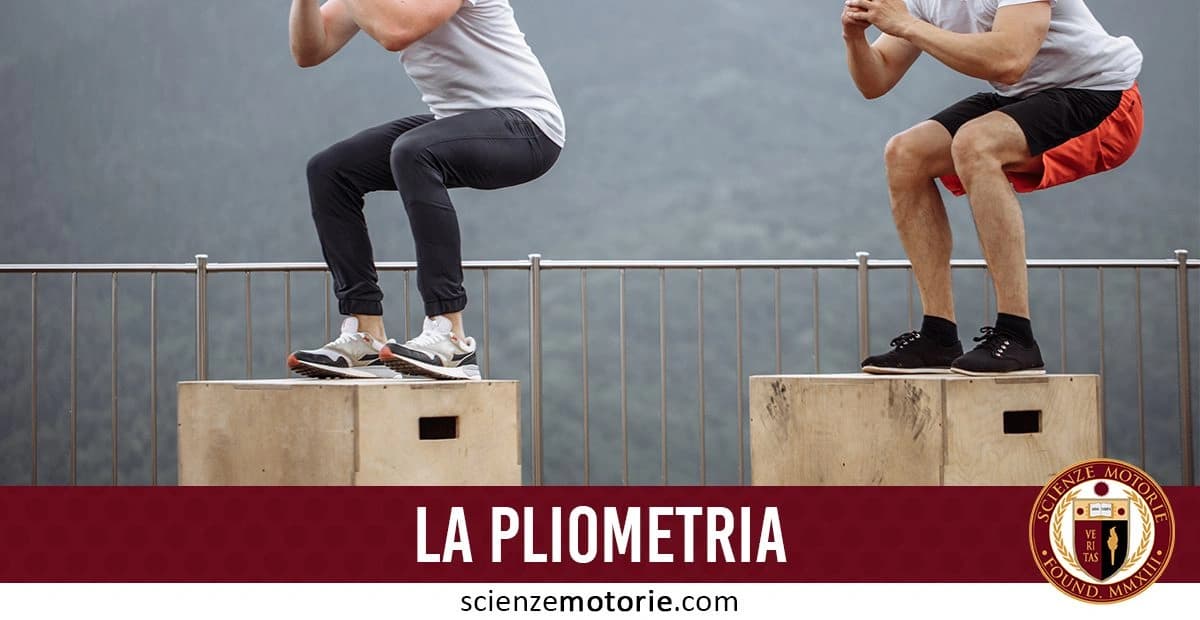 L'immagine mostra due persone che eseguono esercizi di pliometria saltando su scatole. Entrambi indossano abbigliamento sportivo e si trovano in un ambiente all'aperto con una ringhiera metallica sullo sfondo. In basso, c'è una fascia rossa con il testo "LA PLIOMETRIA" e il logo di Scienze Motorie