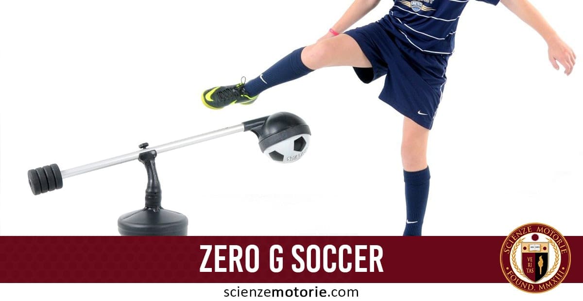 Calciatore in completo blu che calcia un attrezzo di allenamento "Zero G Soccer" con palla montata su braccio meccanico, sfondo bianco, con logo scienzemotorie.com visibile in basso a destra.