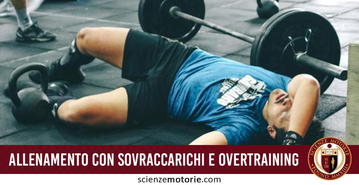 Persona con maglietta blu sdraiata a terra in palestra, affaticata dopo allenamento con bilanciere e kettlebell.
